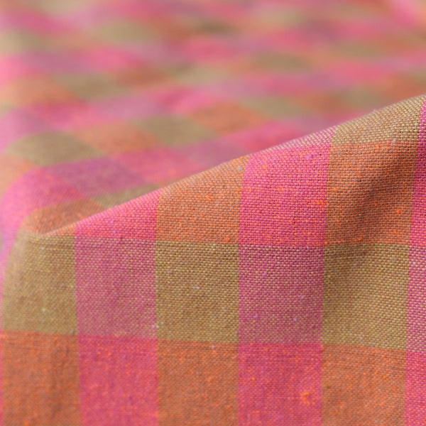 Close-up of a checkered fabric with pink and brown pattern. laid towel with tassels. Checker Gingham Picnic Blanket.
